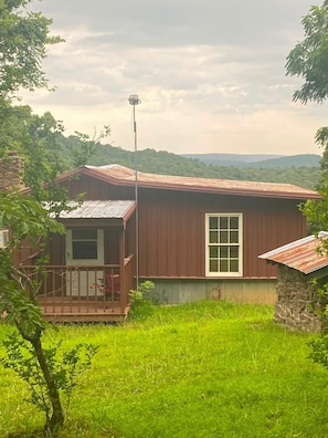 A single-story house with a porch, a small attached garage, and a stone wall. - Hikers and waterfall chaser friendly cabin (Pelsor)