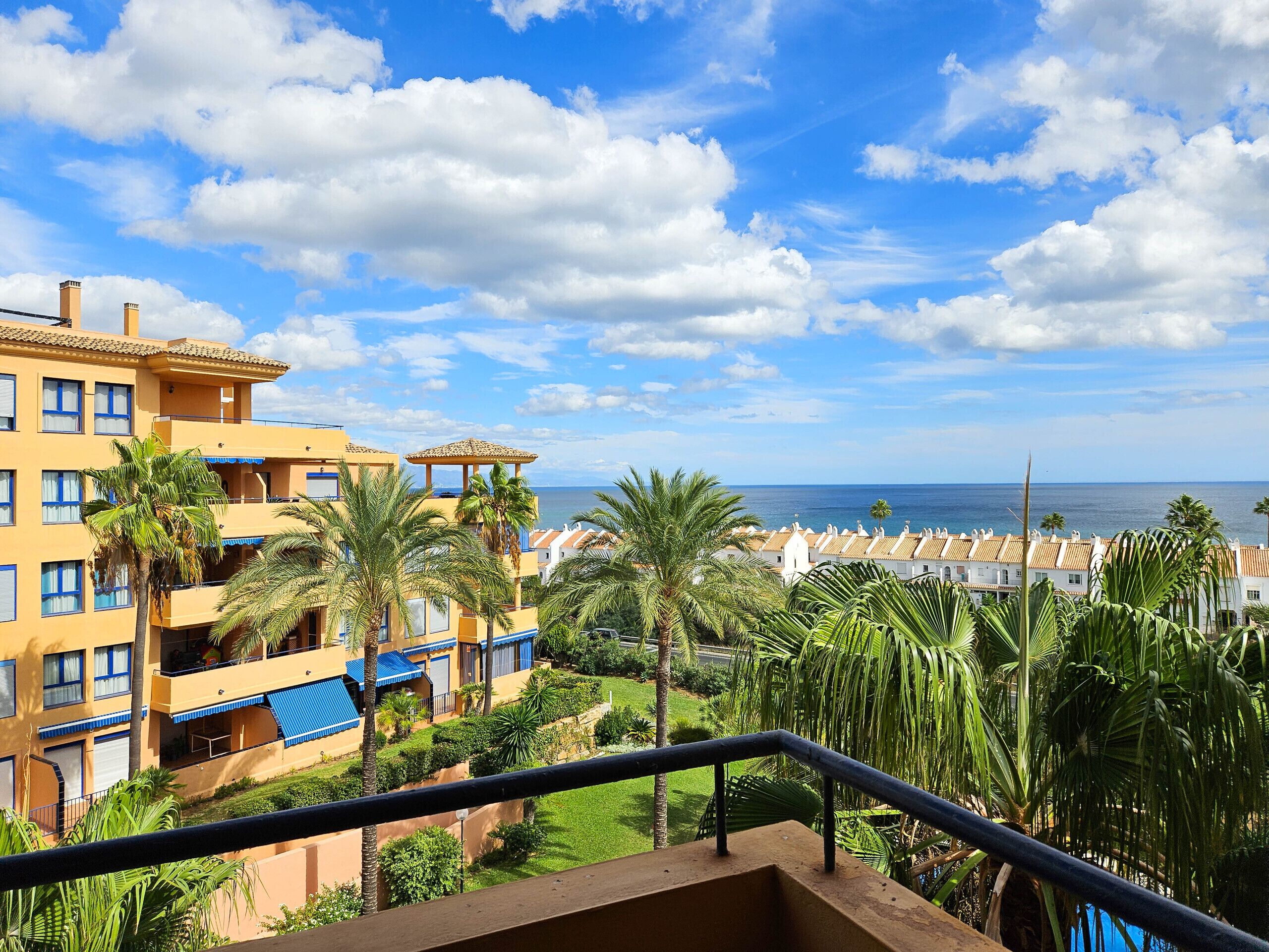 Un hotel con varios pisos, balcones y vista al mar.