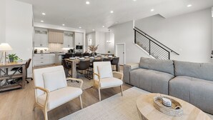 A modern living room with a grey sofa, two white armchairs, and a coffee table. - Desert Beachcomber: Desert Color Lagoon + Beaches (St. George)