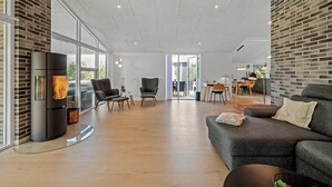 A modern living room with a fireplace, a sofa, and a dining area.