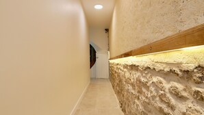 A hallway with a textured wall and a recessed light fixture. - D-DAY SUITES carentanlocation.fr: TERRA - Downtown / 2-minute walk from the train station (Carentan-les-Marais)