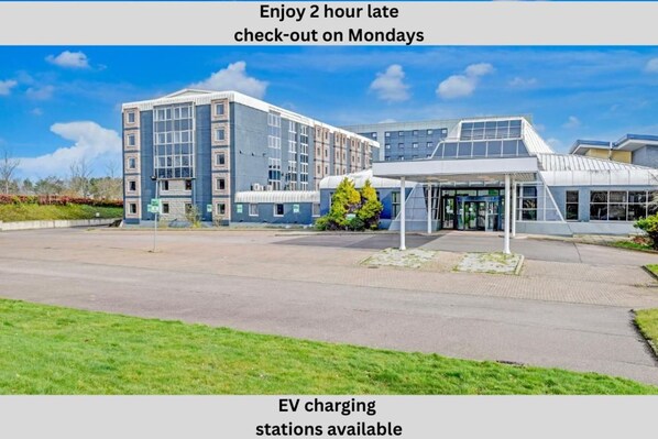 Un bâtiment moderne doté d’une entrée couverte et d’un parking.