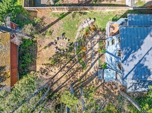 Vista aérea de uma propriedade com área de pátio, mobiliário de exterior e banheira de hidromassagem.