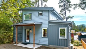 A two-story house with a covered porch, a garage, and a small front yard.