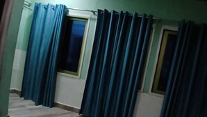 A room with a window, a door, and a curtain. - Rudraksh Home Stay (Varanasi)