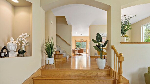 A spacious interior with a wooden staircase leading to a dining area. - 1/2 Acre Retreat: 100" TV, Open layout Navy Base and Six Flags Great America (Gurnee)