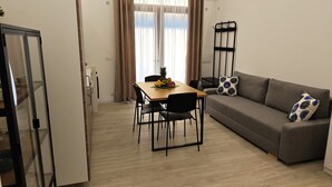 Ein kompakter Wohnbereich mit Essplatz, einer Couch und einer Küchenzeile.