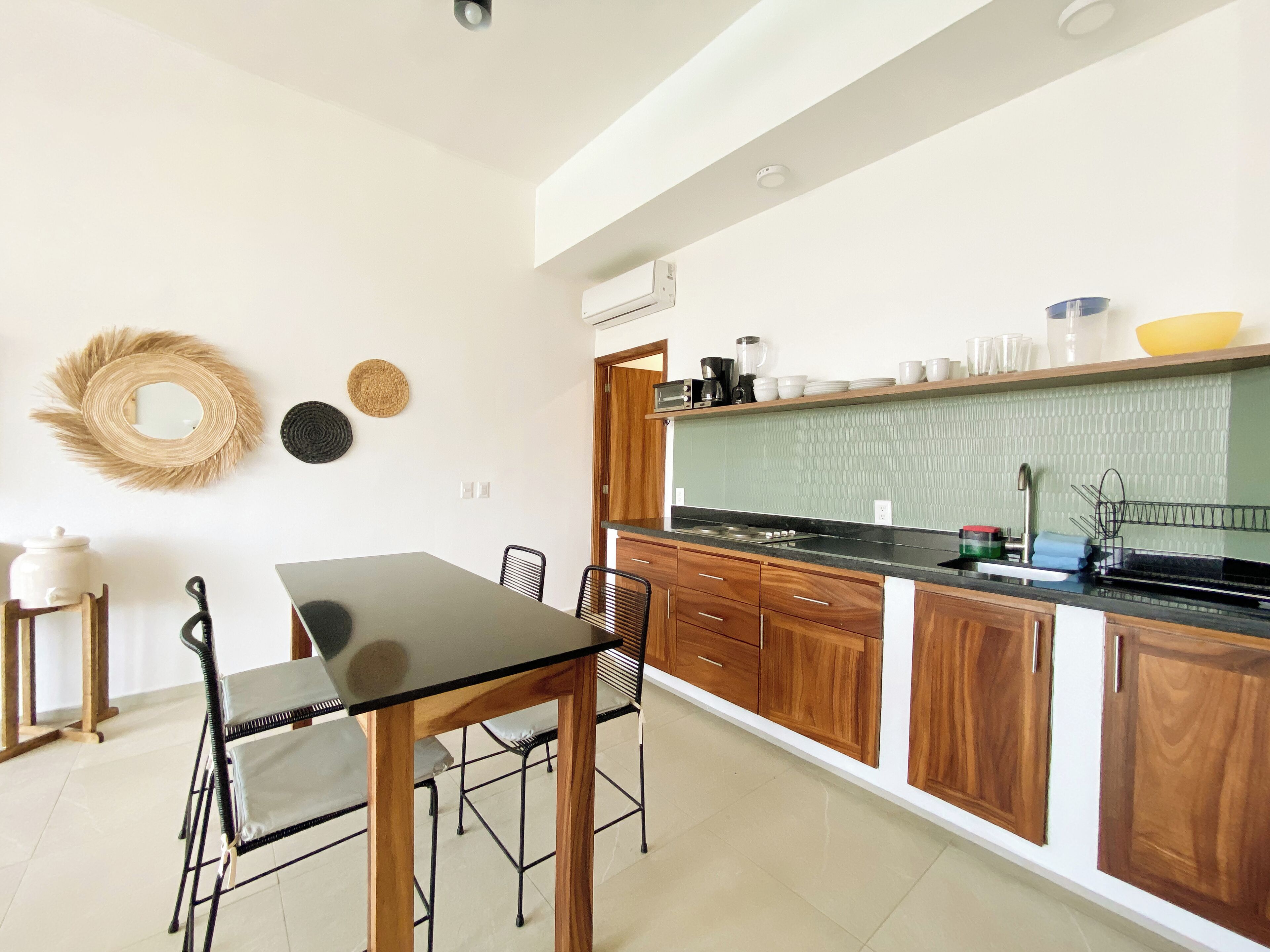 A modern kitchen with a dining table, chairs, and a built-in oven.