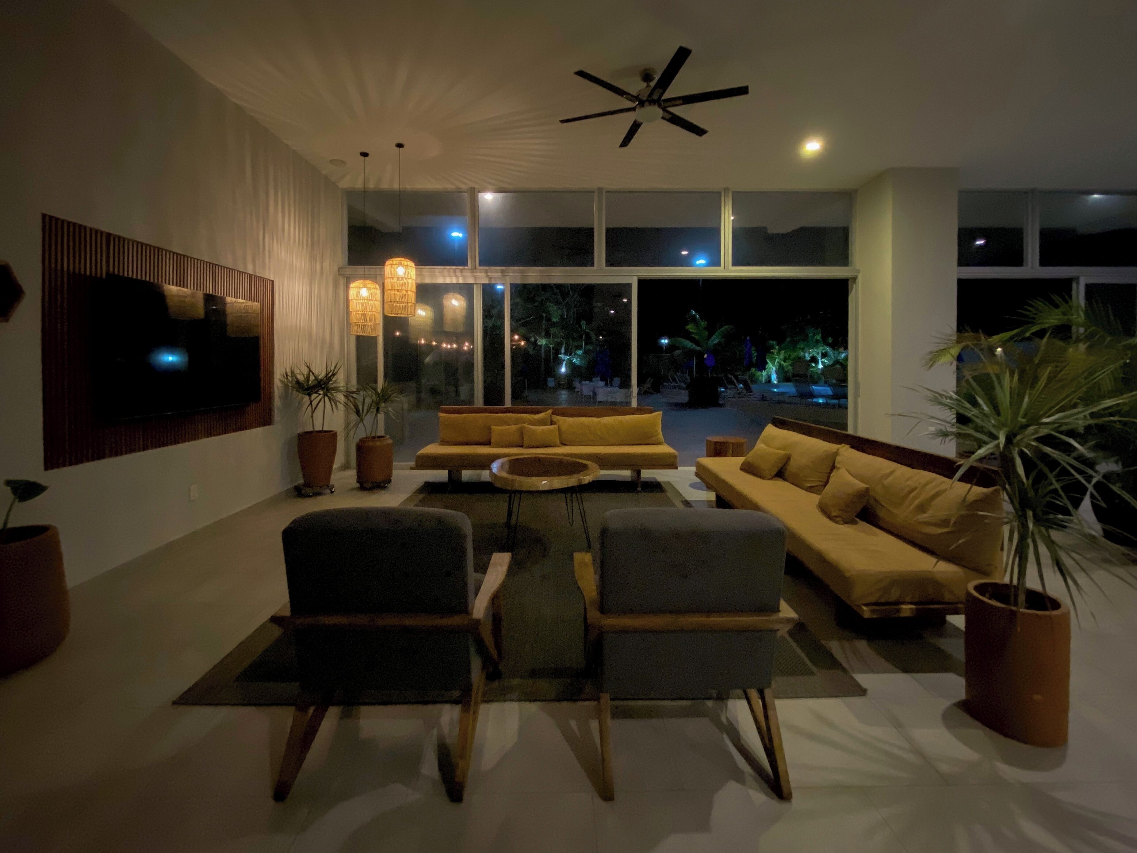 A modern living room with a sofa, chairs, and a TV.