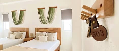 A hotel room with two beds, a wooden headboard, a wall-mounted key holder, and a large window.
