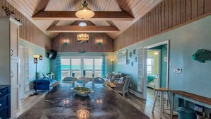 A spacious kitchen with a large island, wooden ceiling, and a view to the outside. - Albion: Dive Into Oceanfront Bliss! (Topsail Beach)