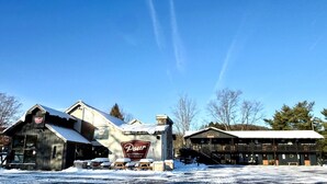 A building with a 'Pour Taproom' sign, a covered outdoor seating area, and a snow-covered ground.