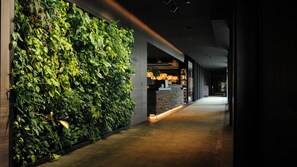 A modern interior with a green wall, a stone counter, and a long corridor. - Anatura Hotel & Spa Luxembourg (Weiswampach)