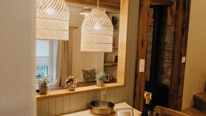 A wooden dining table with hanging lights, a mirror above, and a bench. - La Tanière - Nature and relaxation gîte (Durbuy)