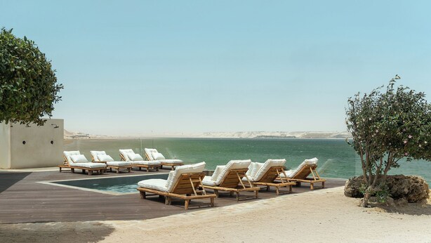 A poolside area with lounge chairs and a view of the sea. - New Spirit Dakhla (Dakhla)