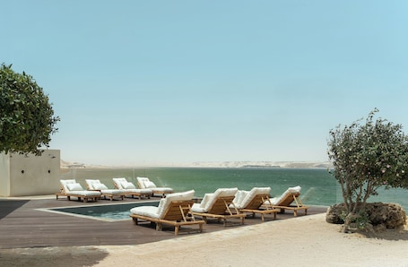 Una piscina al aire libre, sombrillas, sillones reclinables de piscina. New Spirit Dakhla
