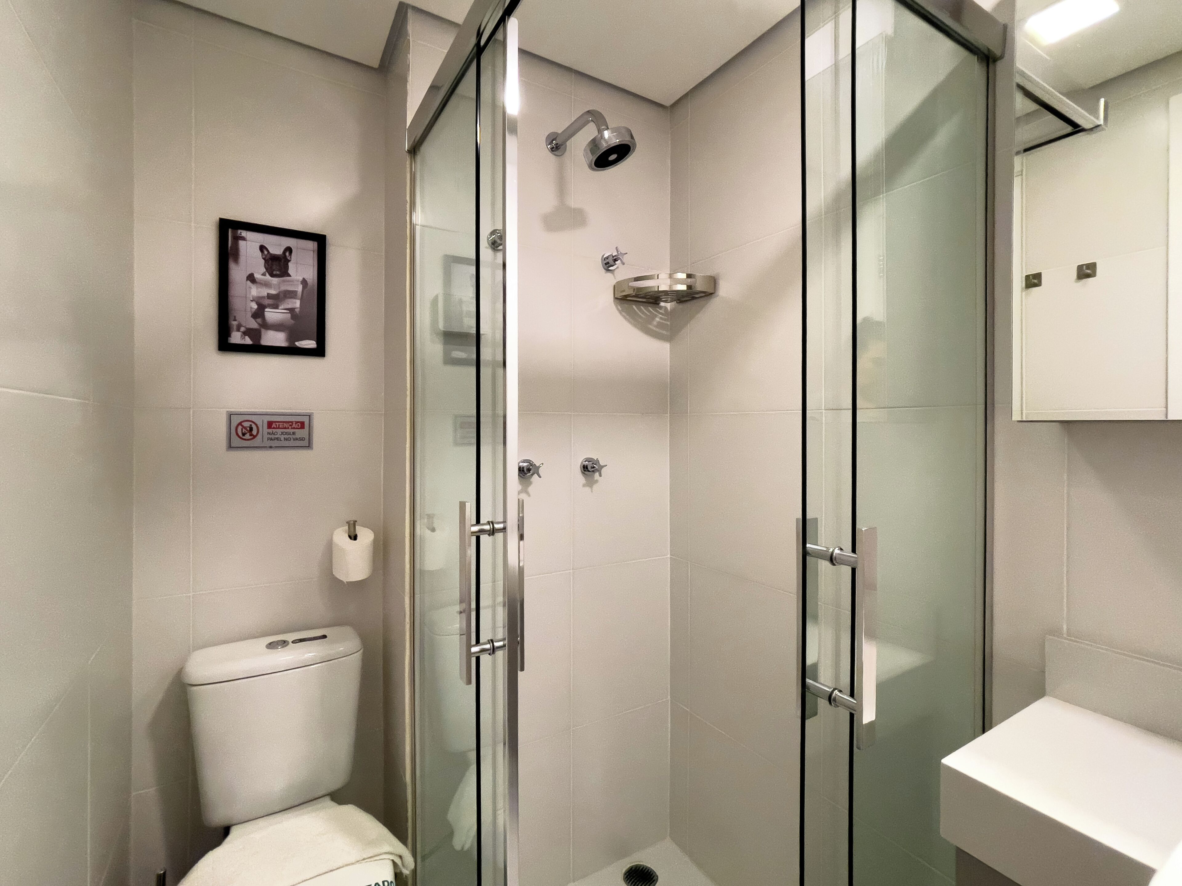 Un bagno moderno con doccia vetro, servizi igienici e lavandino.