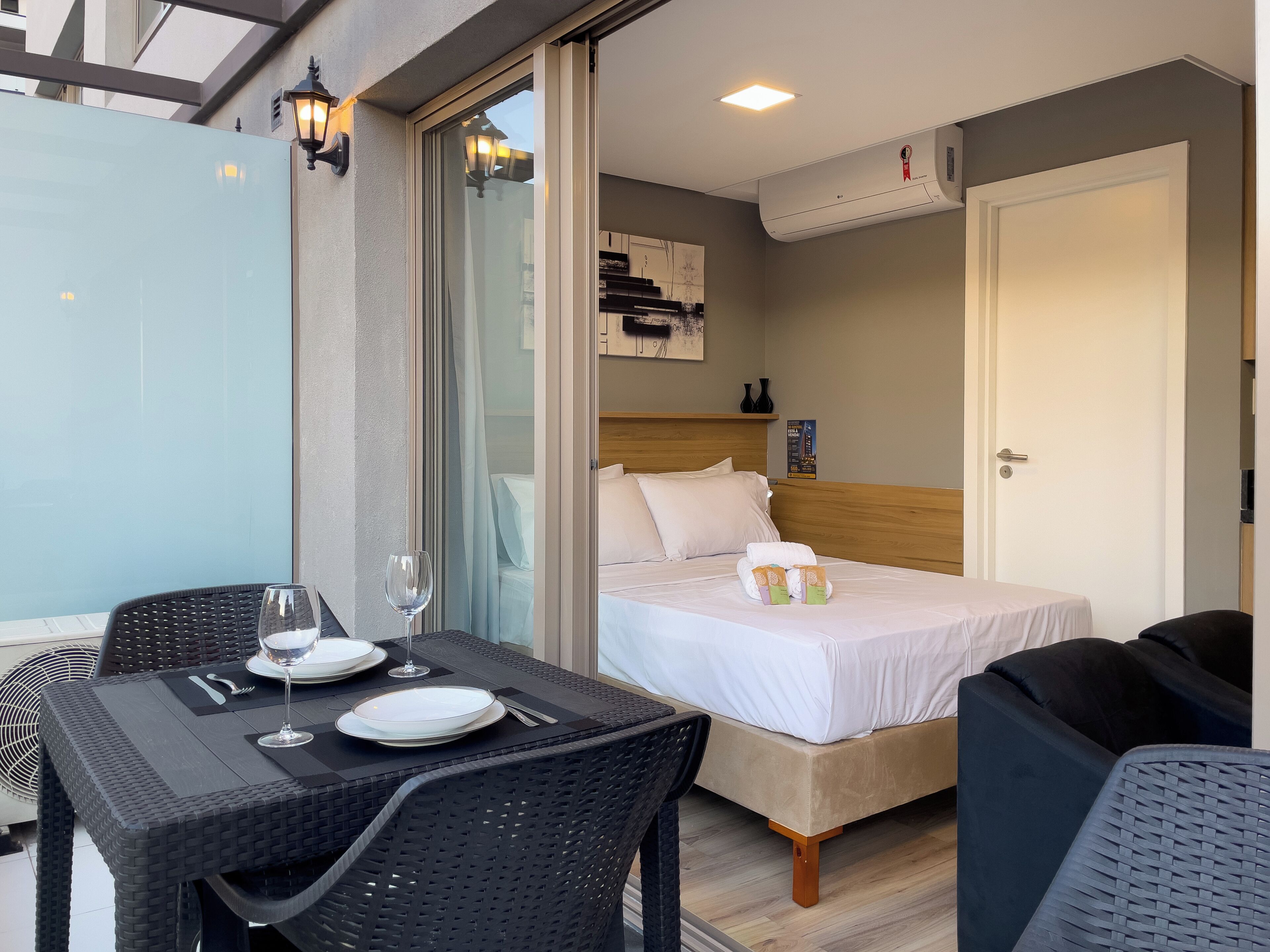 Una habitación de hotel con una cama, una mesa con un vaso y una silla.