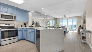Una cocina amplia con armarios azules, una isla grande y vistas al exterior.
