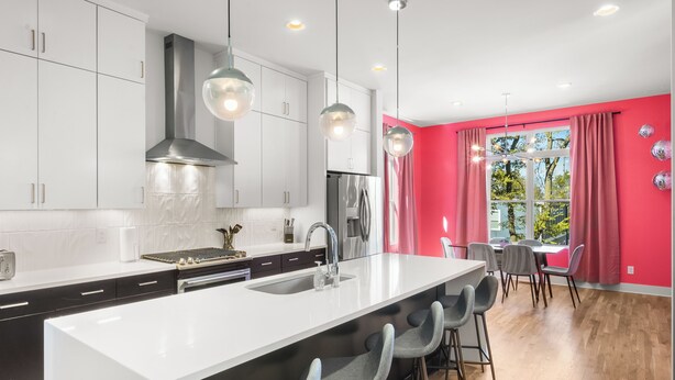 A modern kitchen with a central island, stainless steel appliances, and pendant lighting. - Ultimate Bach 10min to DT, Insta Walls Every Room (Nashville)