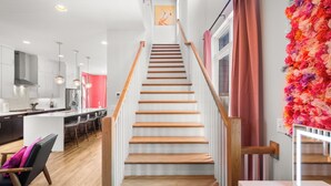 A modern kitchen with white cabinets, a central island, and pendant lighting. - Ultimate Bach 10min to DT, Insta Walls Every Room (Nashville)