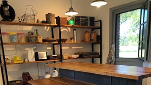 Une cuisine dotée d’un îlot central, d’étagères en bois et de divers appareils de cuisine.