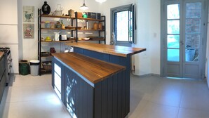 A kitchen with a wooden island, built-in shelves, and a window.