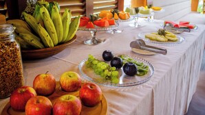 A table with various fruits and a jar of granola. - Awara Pousada Boutique (São Miguel do Gostoso)