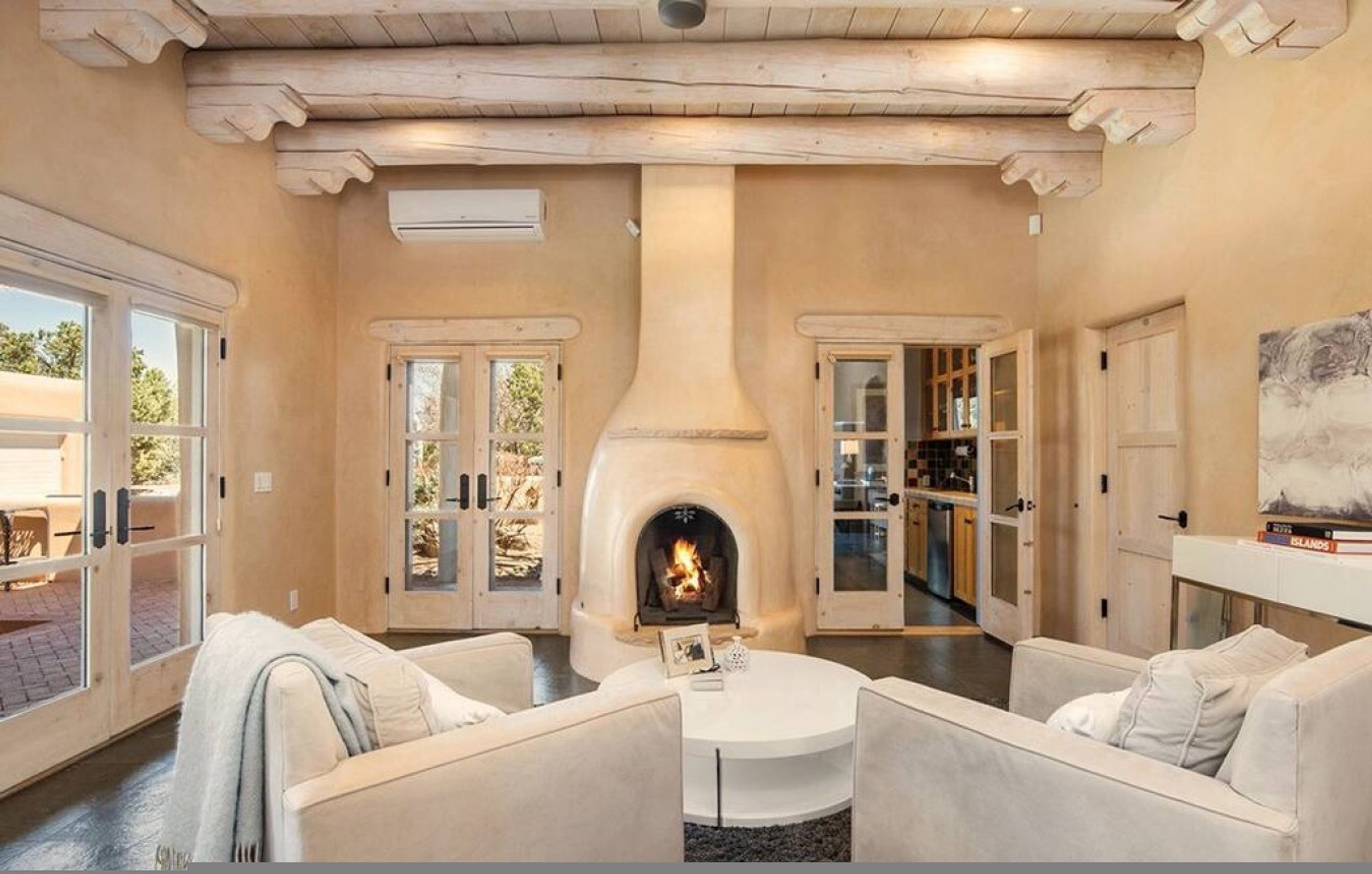 A cozy living room with a fireplace, a round coffee table, and a sofa.