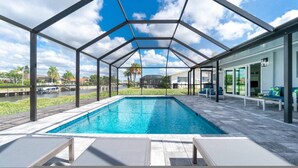 Una piscina techada con vistas a una zona residencial y una masa de agua.
