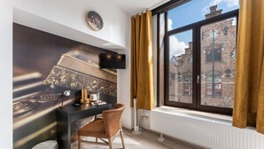 A modern room with a desk, chair, and a large window with curtains.