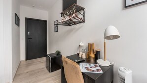 A modern room with a black desk, a white lamp, a magazine, and a wall-mounted coat rack. - Homer Simpson's Donut Room - Steps from the Belfry (Brugge)
