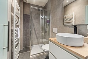 A modern bathroom with a glass-enclosed shower, a white sink, and a toilet. - The Hot Chocolate Room by Charlie`s Choco Factory (Brugge)