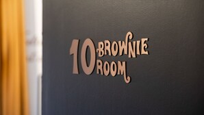 Un cartel con el texto '10 Brownie Room' sobre una pared oscura.