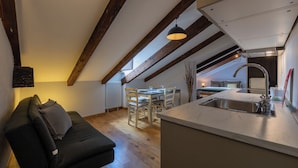 A cozy loft-style room with a dining area, kitchenette, and a sofa. - Barbaroux Apartments by Wonderful Italy (Turin)