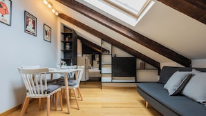 A loft-style room with a dining area, a sofa, and a skylight. - Barbaroux Apartments by Wonderful Italy (Turin)