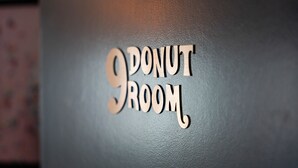 Una pared con el texto "9 DONUT ROOM" en una tipografía estilizada.