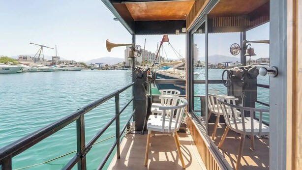 A boat deck with a view of the marina, including boats and buildings in the background.