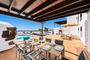 A rooftop terrace with a pool, dining area, and a view of the city. - Villa Valiente - Four Bedroom Villa, Sleeps 8 (Tías)