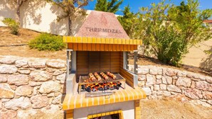 A barbecue grill with the brand name 'PERMOZEL' on the front, surrounded by stone walls and greenery. - Villa Daphne - Two Bedroom Villa, Sleeps 4 (Kalathos)