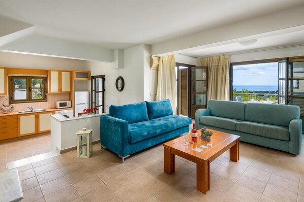 Un apartamento moderno con cocina, dos sofás, una mesa de comedor y un balcón con vistas.