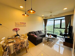 Un salon moderne comprenant un coin repas, un canapé, un téléviseur et un balcon avec vue.