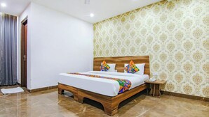 A hotel room with a wooden bed, a patterned wallpaper, and a tiled floor. - Hotel Divine Residency by JMD Group (New Delhi)