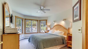 A bedroom with a bed, a wooden nightstand, a dresser, and a ceiling fan. - Ski-In/Ski-Out at Jay Peak Resort Condo! (Jay)