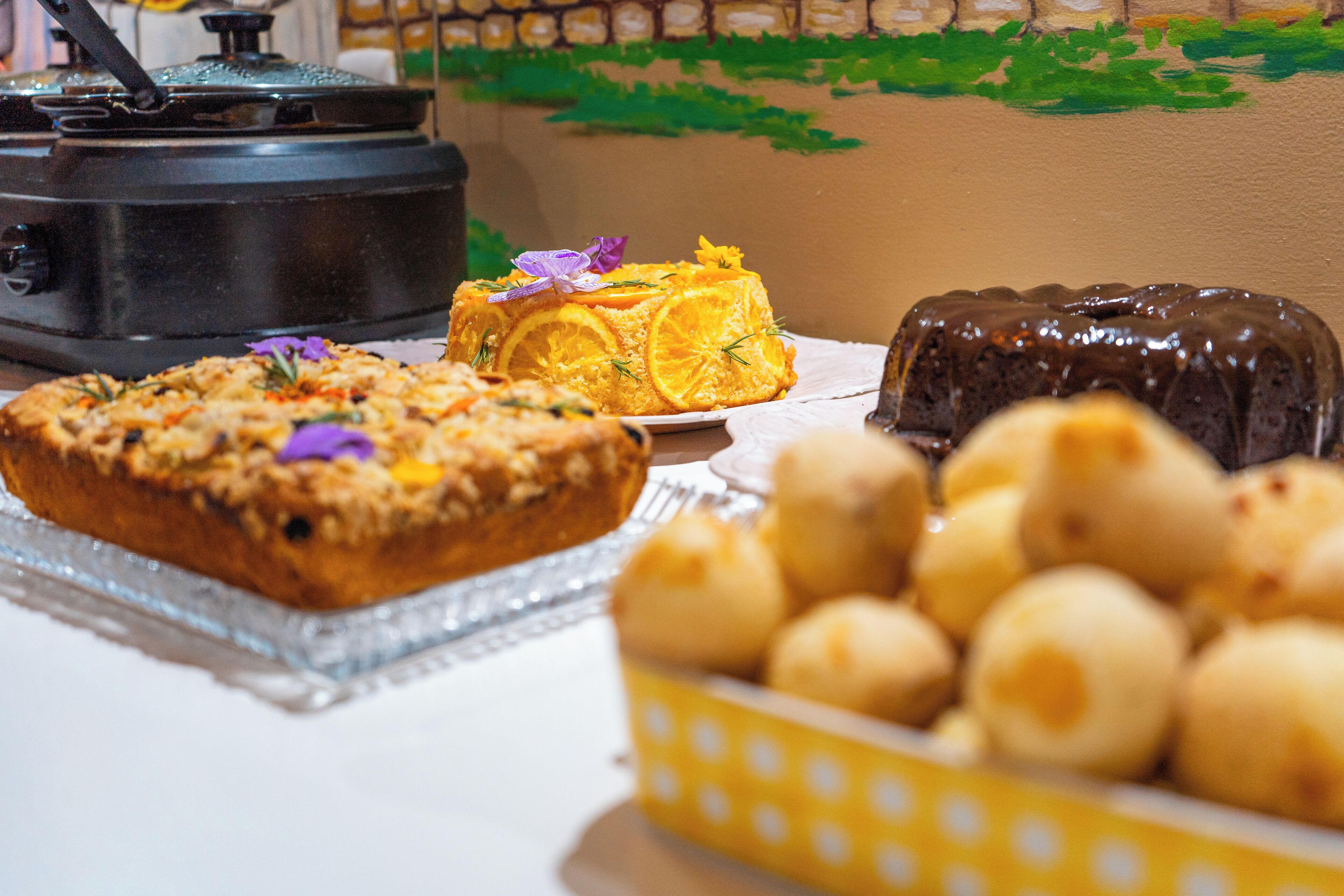 A variety of baked goods on a table, including a loaf of bread, a cake, and a chocolate dessert.