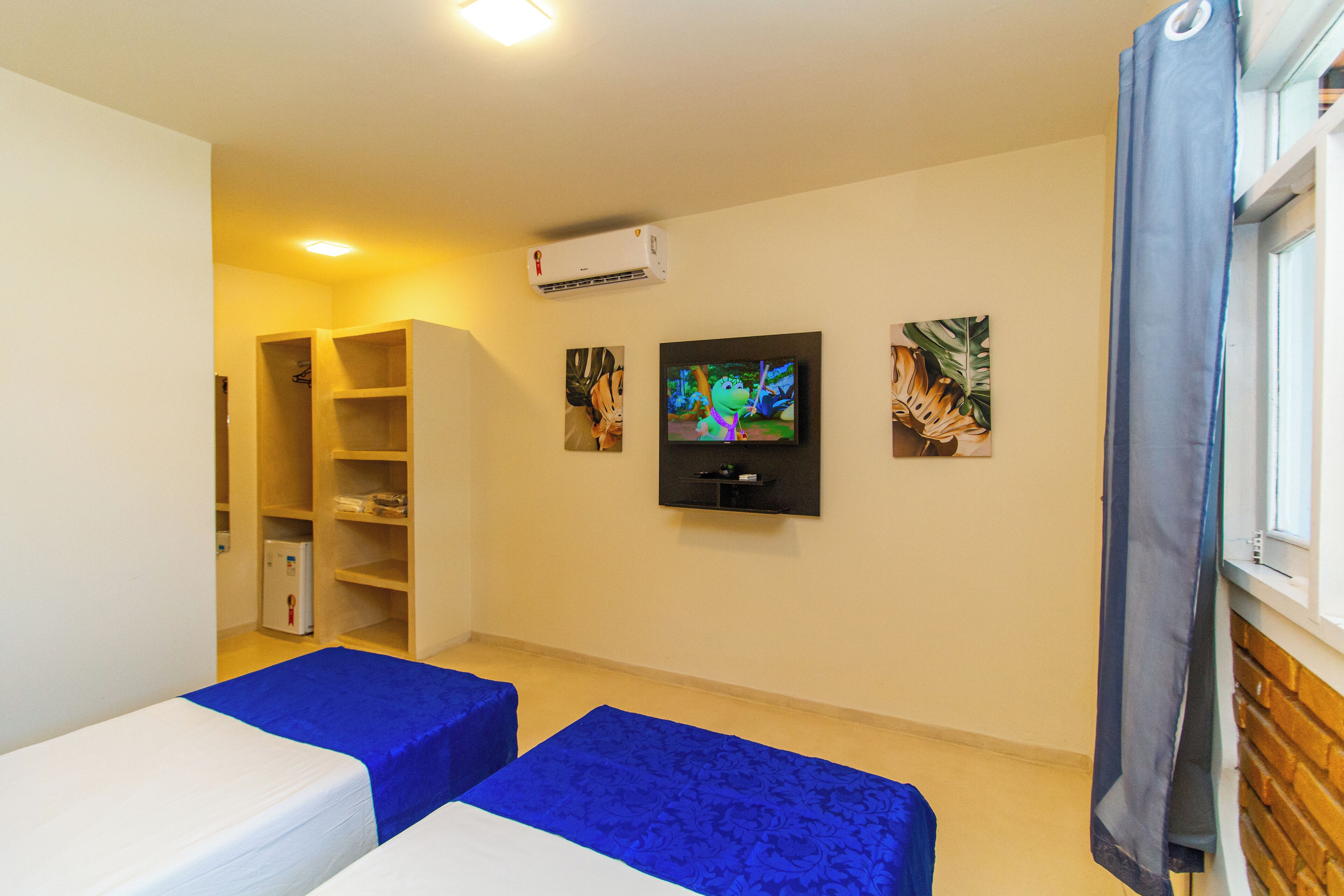 A room with two beds, a TV, and a wardrobe.