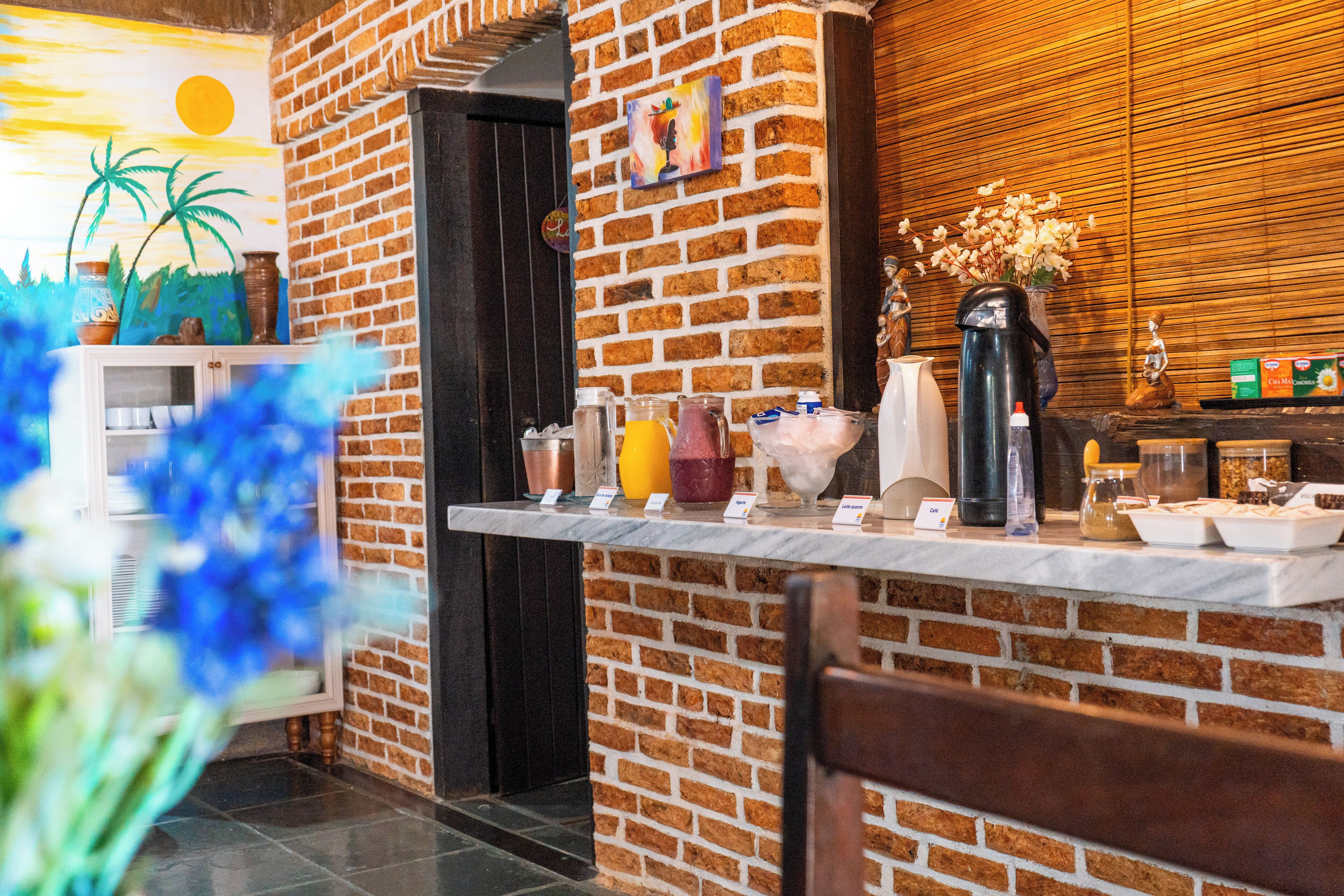 Pared de ladrillo con un panel de madera y una estación de café con varios artículos.