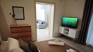 Ein modernes Wohnzimmer mit einer Couch, einem Couchtisch, einem Fernseher und einer Holzkommode.