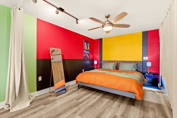 A bedroom with a bed, a ceiling fan, and a mirror. - Six Flags/The Rim - Chic Modern Studio, King Bed (San Antonio)