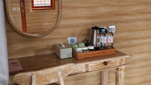 A wooden desk with a mirror, a small window, and a tray with toiletries. - Green Pacing Lodge (Tembuku)